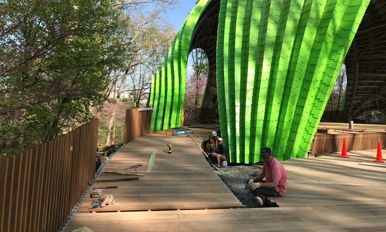 The wooden boardwalk and ramp leading to the Chrysalis stage. (Click for a higher-resolution version.)  The boardwalk abuts the clay pavers in front of the stage where the traffic cones are placed. Image © 2017 Inner Arbor Trust; used with permission.