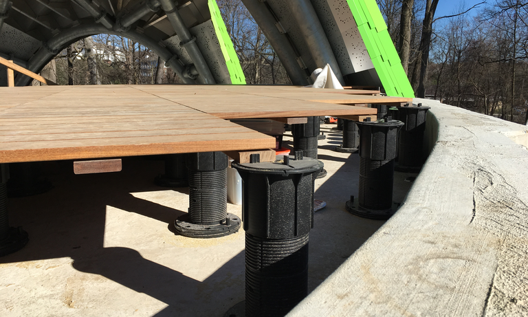 The stage floor of the Chrysalis in the process of being installed. (Click for a higher-resolution version.) The black cylinders are Bison adjustable deck supports, each holding up one corner of four adjacent wooden tiles. Image © 2017 Frank Hecker; available under the terms of the Creative Commons Attribution 4.0 International License.