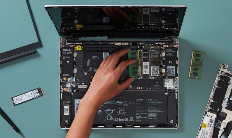 A Framework laptop partially assembled, showing the memory, motherboard, and battery. From the Framework DIY Quick Start Guide.